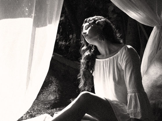 AZURE, artist lounging on a daybed in a tropical place.