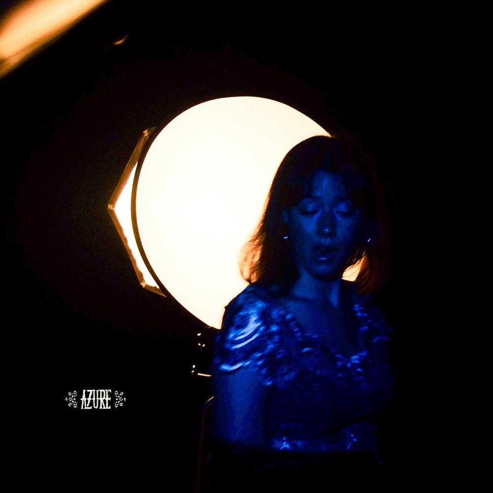 AZURE, Swiss artist, cover art for latest single, High Note. AZURE in blue in front of large spot