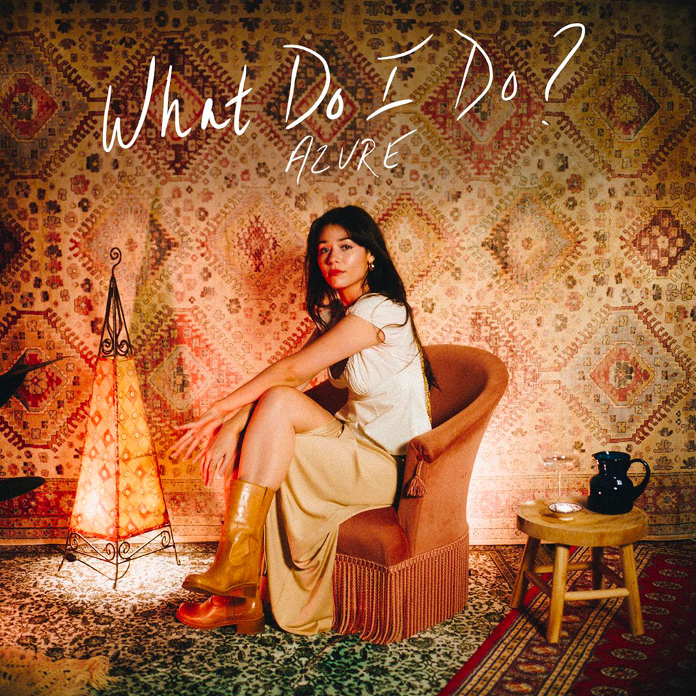 AZURE artist sitting in chair with mosaic background. Single what Do I Do? cover art